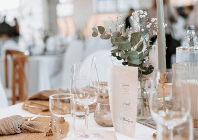 Detailaufnahme einer stilvollen Tischdekoration mit Menükarte, Kerzen und floralen Elementen bei einer Hochzeit in der Alten Lehrwerkstatt Solingen