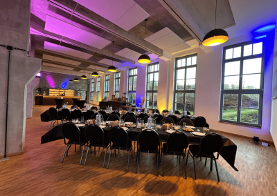 Gedeckte Tische für ein Business-Dinner in der Lehrwerkstatt Solingen mit stimmungsvoller Beleuchtung