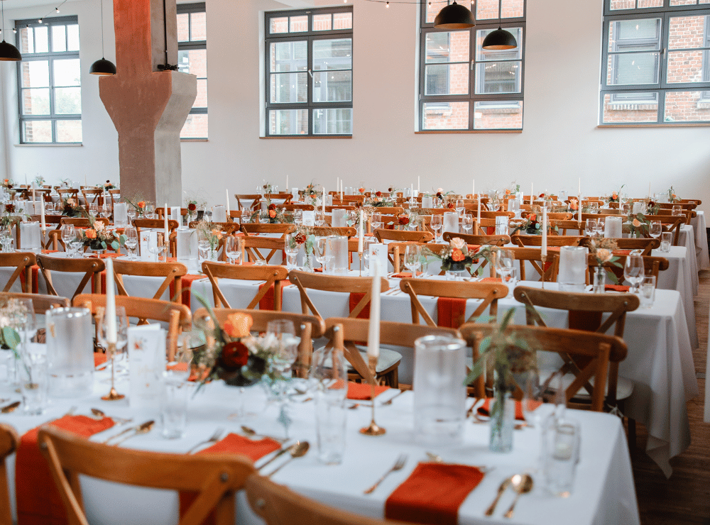 Großzügige Raumaufnahme der Alten Lehrwerkstatt Solingen mit langen Hochzeitstafeln, Bankettbestuhlung und Platz für viele Gäste bei einer Hochzeitsfeier