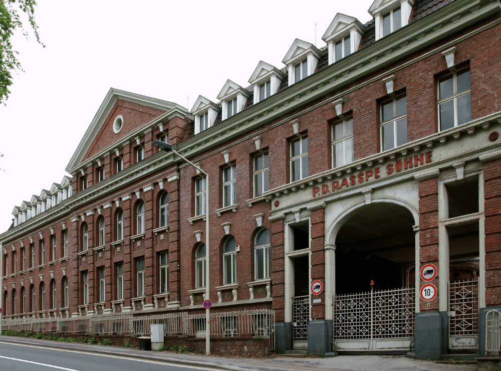 Frontansicht des historischen Hauptgebäudes auf dem ehemaligen P. D.-Rasspe-Gelände in Solingen – Zugang zur Alten Lehrwerkstatt auf dem Gelände dahinter